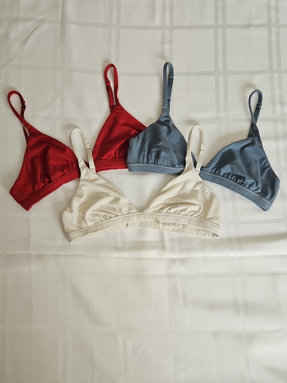 SKIMS Fits Everybody Triangle Bralettes in Red, Steel Blue, and Bone